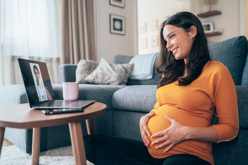 A pregnant woman having a video call with a doctor